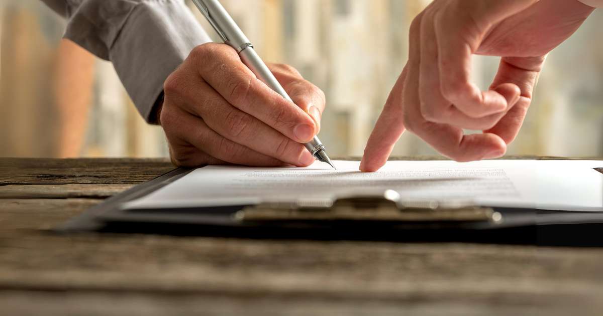 Mains en train de signer un document