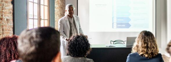 Formateur expérimenté en formation professionnelle pour adultes après 50 ans, transmettant son savoir devant un groupe d’apprenants.
