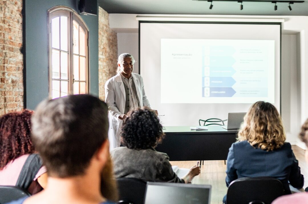 Formateur expérimenté en formation professionnelle pour adultes après 50 ans, transmettant son savoir devant un groupe d’apprenants.